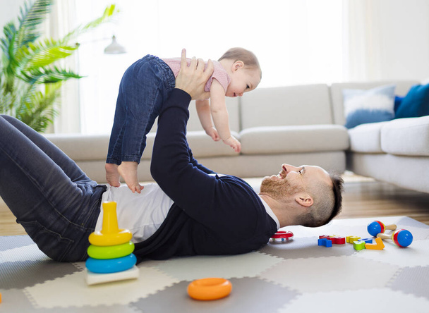 man playing with her baby in the living room - Photo, Image