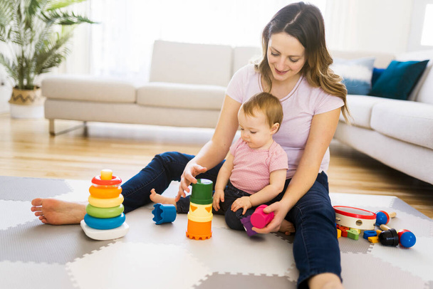 woman playing with her baby in the living room - Photo, image