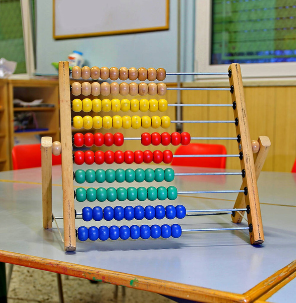 aula di un Kingergarten con abaco sul tavolo e sedie rosse - Foto, immagini