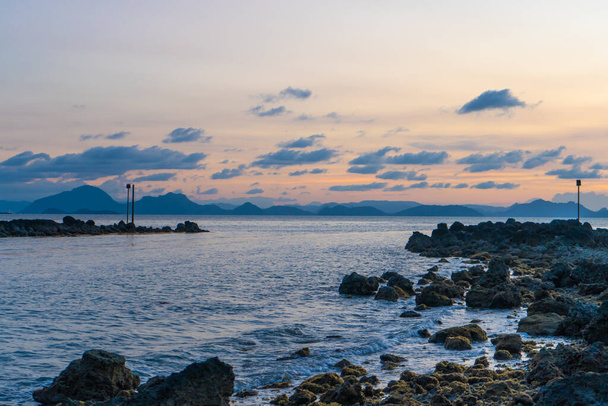 Meraviglioso paesaggio al tramonto sulla riva del mare, colori del cielo al tramonto e silhouette dell'isola in acqua. incredibile tramonto tropicale. - Foto, immagini