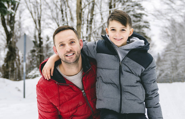 Handsome dad and his son are having fun outdoor in winter - Fotó, kép