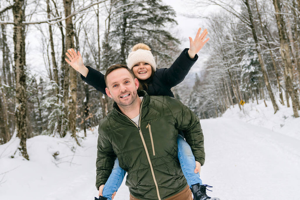 Handsome dad and his daughter are having fun outdoor in winter - Foto, Imagen