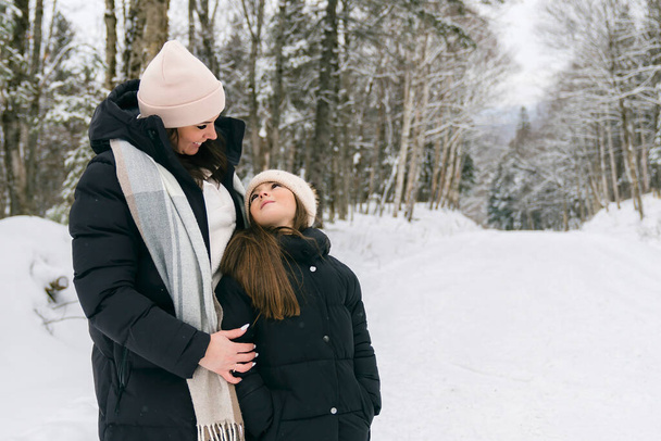 Handsome mother and his daughter are having fun outdoor in winter - Foto, Bild