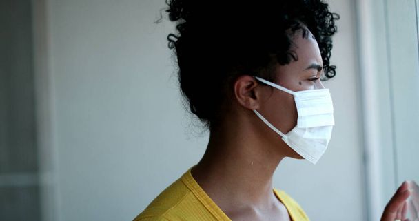 Young African American woman putting face mask - Фото, зображення