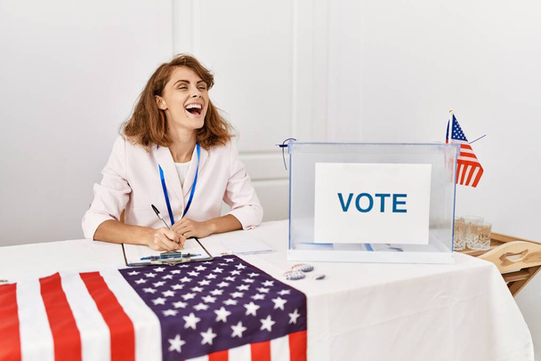 Giovane operaio del partito politico americano sorridente felice di lavorare al collegio elettorale. - Foto, immagini