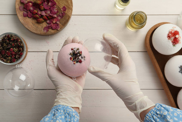 Woman in gloves with self made bath bomb at white table, top view - Foto, Imagem