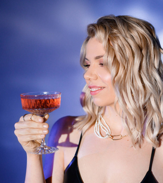 Close-up portrait of a blonde girl with a glass - Photo, image