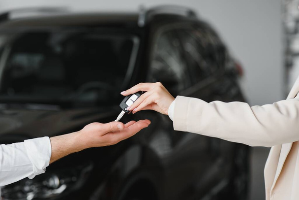 businessman exchange handing over the car keys for to a young women - Fotó, kép