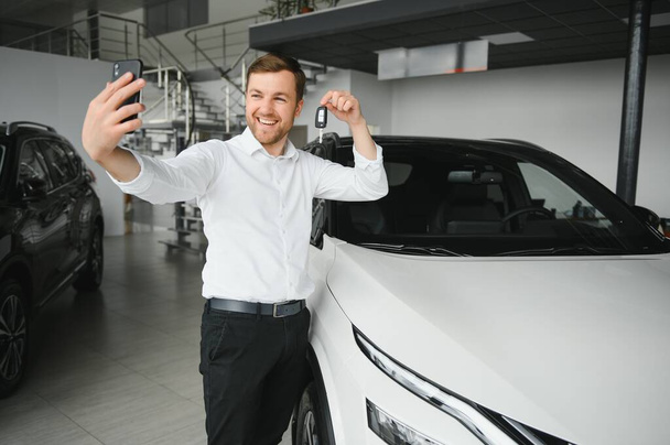 Man buying a car at a showroom. - Zdjęcie, obraz
