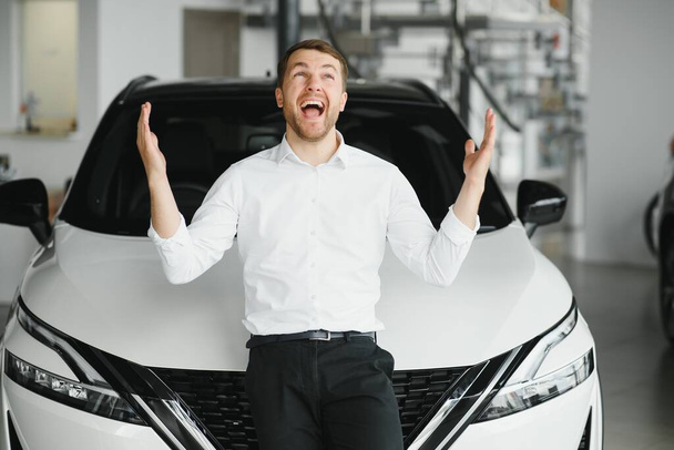 Man buying a car at a showroom. - Фото, изображение