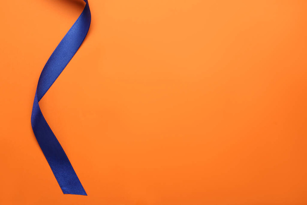 Beautiful blue ribbon on orange background, top view. Space for text - Photo, Image