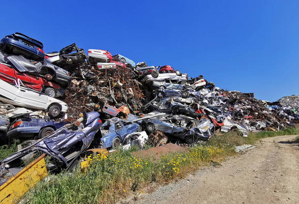 Pile of various scrap cars and other metals on a junk yard ready recycling industry. - Fotó, kép