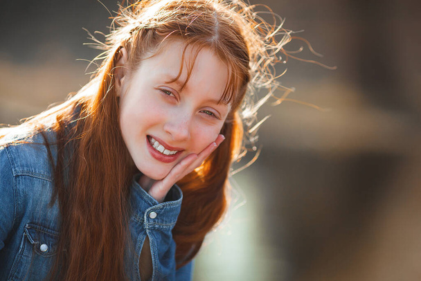 Cute red haired girl portrait. Pretty teen outdoors. Redhaired teenager. - Foto, imagen