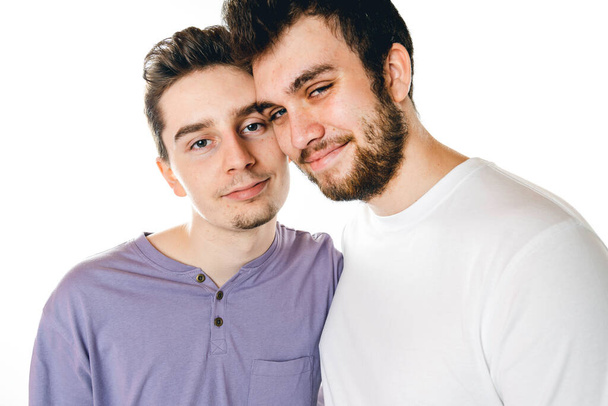 Young gay couple standing together over isolated background - Fotó, kép
