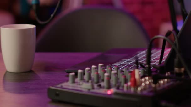 Selective focus on laptop keyboard and knobs of audio mixer on podcasting desk - Filmmaterial, Video