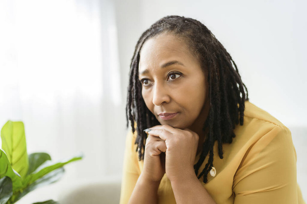 Portrait of an african woman sit on the sofa look worry - Fotó, kép