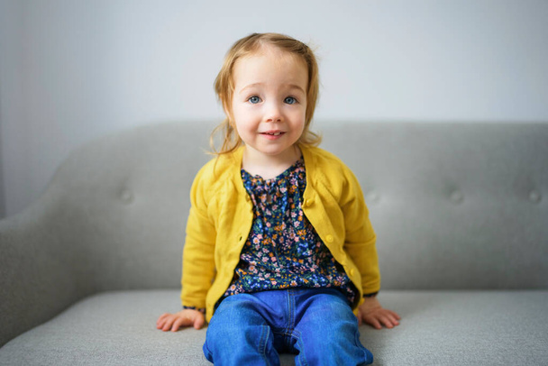 Adorable baby girl sit on sofa at home - Fotografie, Obrázek