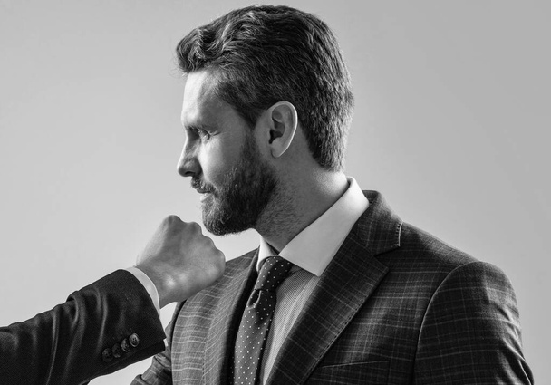 Professioneller Mann Manager nimmt männlichen Faustschlag ins Gesicht grauen Hintergrund, Uppercut - Foto, Bild