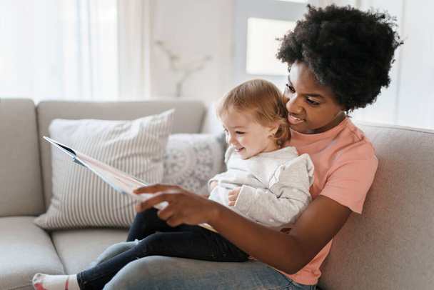 nursery babysitter with baby reading a book - Zdjęcie, obraz