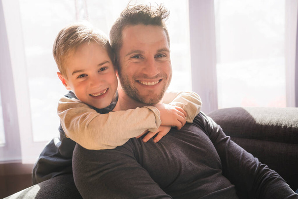 father and son sit on the sofa at home - Fotoğraf, Görsel