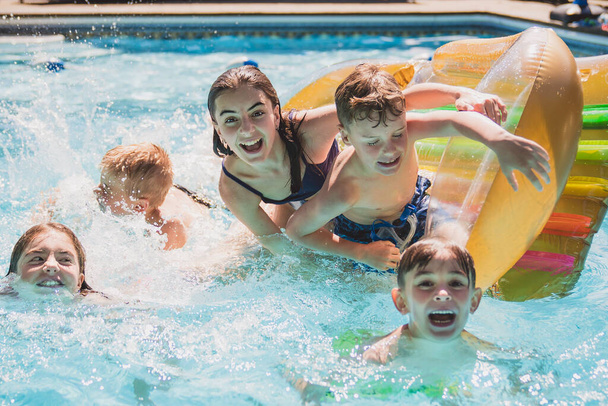 group of children having fun in Pool on the summer time - Фото, изображение