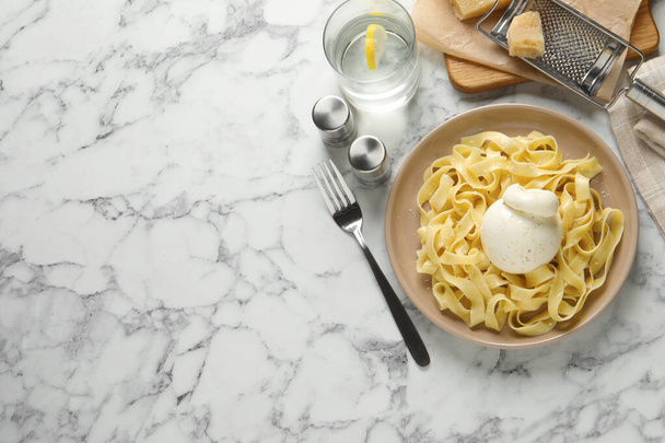Delicious pasta with burrata cheese served on white marble table, flat lay. Space for text - 写真・画像