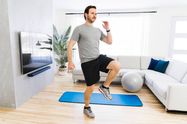 Attractive Fit man Exercise at home on the living room - Foto, Bild