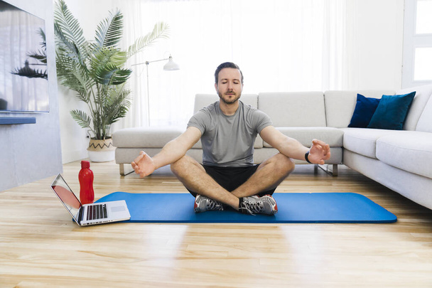 Attractive Fit man Exercise at home on the living room - Foto, afbeelding