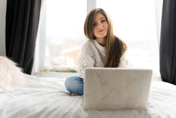 Child girl with computers on bed at home - Photo, image