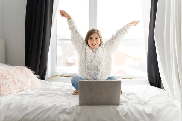Child girl with computers on bed at home - Foto, Imagem