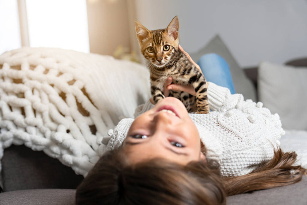 Bengal cat in the living room on the couch with child - Fotografie, Obrázek