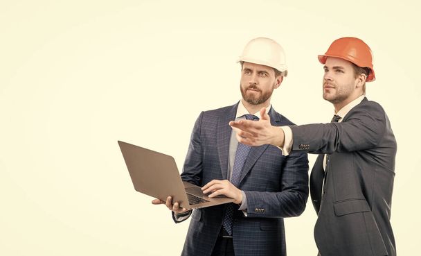 deux ingénieurs en combinaison et casque de protection utilisation ordinateur portable isolé sur l'espace de copie blanche, entreprise de sécurité - Photo, image