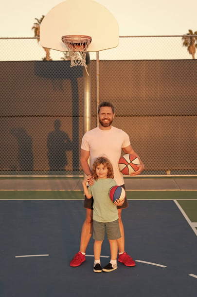 felice papà e figlio giocare a basket con la palla sul parco giochi, paternità - Foto, immagini