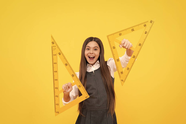happy child hold math triangle ruler in school on yellow background, education - Photo, Image