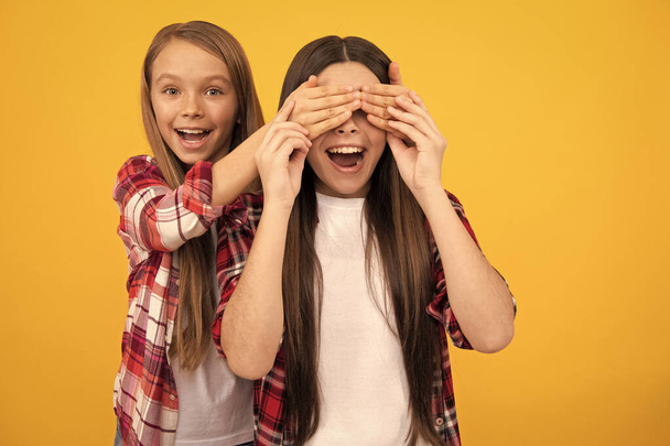 happy children in casual checkered shirt having fun closing eyes on yellow background, guess who - Фото, изображение