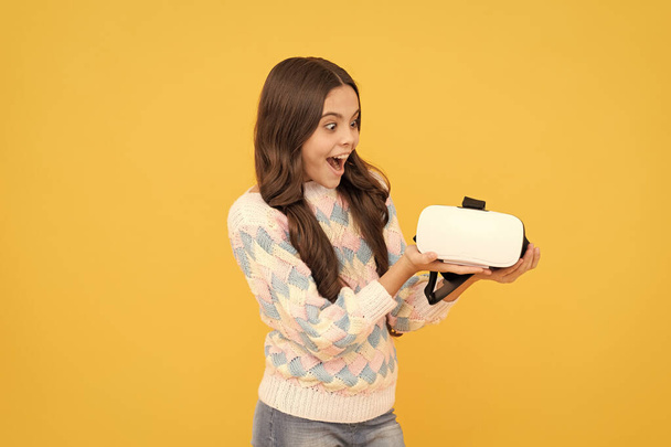 modern vezeték nélküli technológia. gyermekkori fejlődés. elképedt tini lány tart vezeték nélküli VR szemüveg. - Fotó, kép