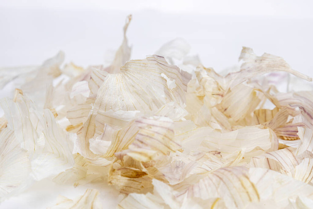 Φλούδα σκόρδου απομονώνονται σε λευκό φόντο, φλούδα σκόρδου που χρησιμοποιούνται συχνά στη λαϊκή ιατρική, υγιή φυσικά προϊόντα - Φωτογραφία, εικόνα