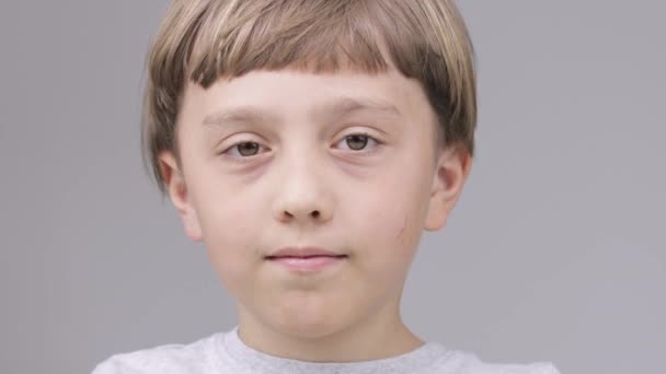 A 9 éves kaukázusi fiú azt mutatja, hogy mosolyog a hüvelykujjával - Felvétel, videó