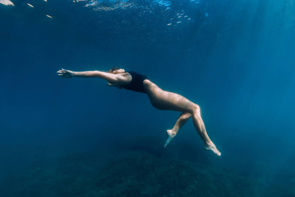 青い海の中で水中でポーズをとる女性。美しいです女性でセクシービキニundewater - 写真・画像