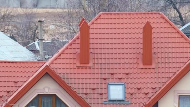 Domy mieszkalne z dachami pokrytymi gontami metalowymi i ceramicznymi na obszarach wiejskich podmiejskich - Materiał filmowy, wideo