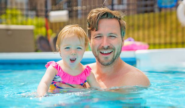 father with the child girl in the pool - Foto, imagen