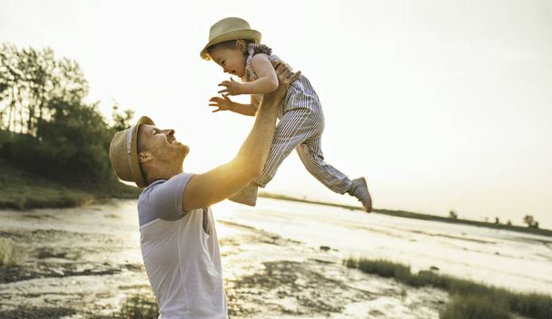 Father have fun with baby on the beach at the sunset - Foto, Bild