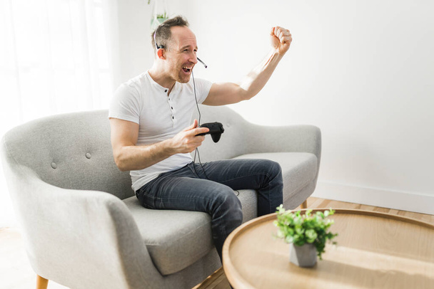 Concentrated man having fun with video games while on a sofa - Fotografie, Obrázek