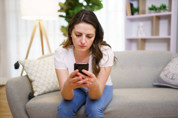 Молодая женщина отправляет смс со смартфоном - Фото, изображение