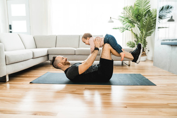 Nice father training with his baby at home - Foto, Bild