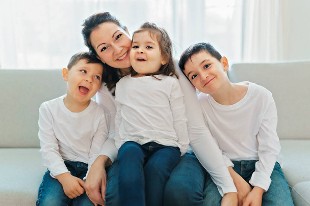 Loving mother with kids enjoying time together at home sofa - Foto, Bild
