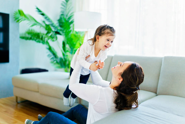 Mother with her daughter having fun in living room at home - Foto, Bild