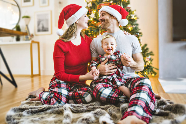 Christmas family with baby close to a tree - Foto, immagini