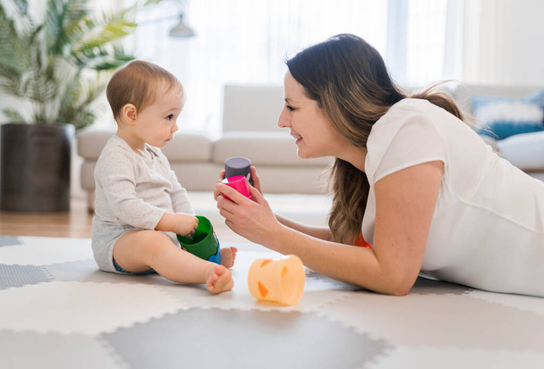 woman playing with her baby in the living room - Photo, image