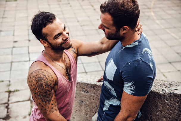 A Portrait of a happy gay couple outdoors in urban background - Fotó, kép